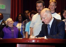 Gov. Jerry Brown signs a bill in September to raise the state's minimum wage. Photo: Nick Ut, Associated Press