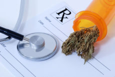 12566026 - cannabis bud sitting on a prescription pad, near a stethoscope