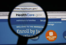 34778261 - lisbon - january 14, 2014: photo of healthcare.gov homepage on a monitor screen through a magnifying glass.