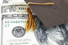 13044485 - mini graduation cap on money