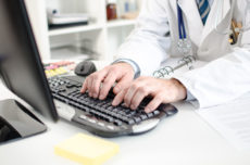 33919068 - doctor typing on a computer keyboard at office