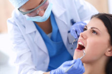 43397789 - woman dentist working at her patients teeth .