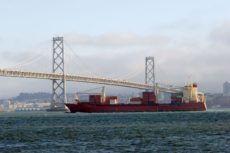 528661 - crgo ship under bay bridge with san francisco on background